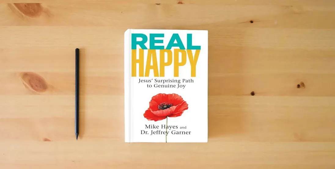 The book Real Happy: Jesus' Surprising Path to Genuine Joy} is on the table