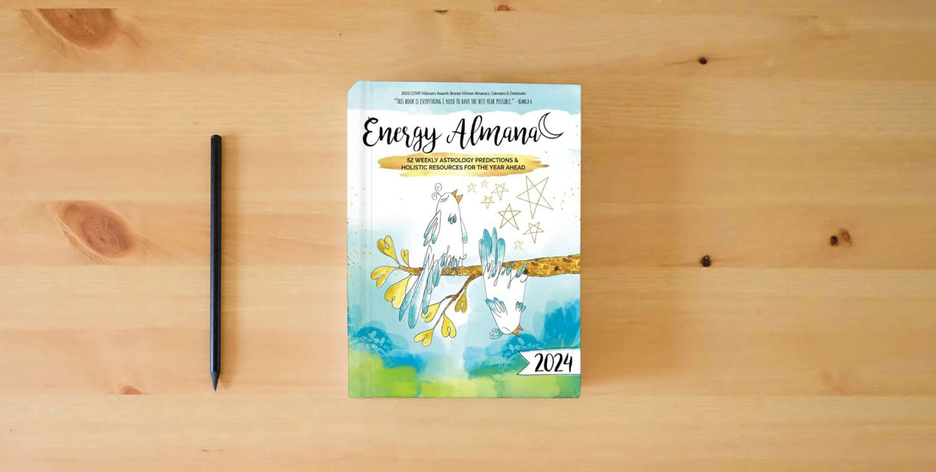 The book 2024 Energy Almanac: 52 Weekly Astrology Predictions & Holistic Resources for the Year Ahead is on the table