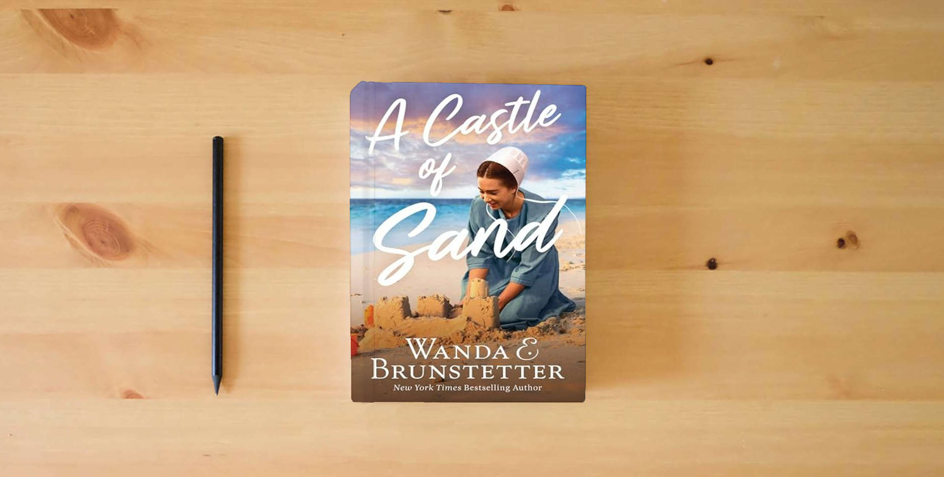 The book A Castle of Sand is on the table