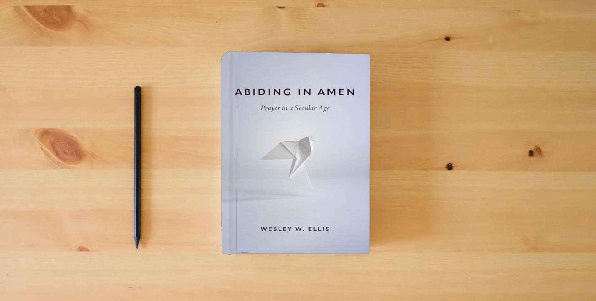 The book Abiding in Amen: Prayer in a Secular Age is on the table