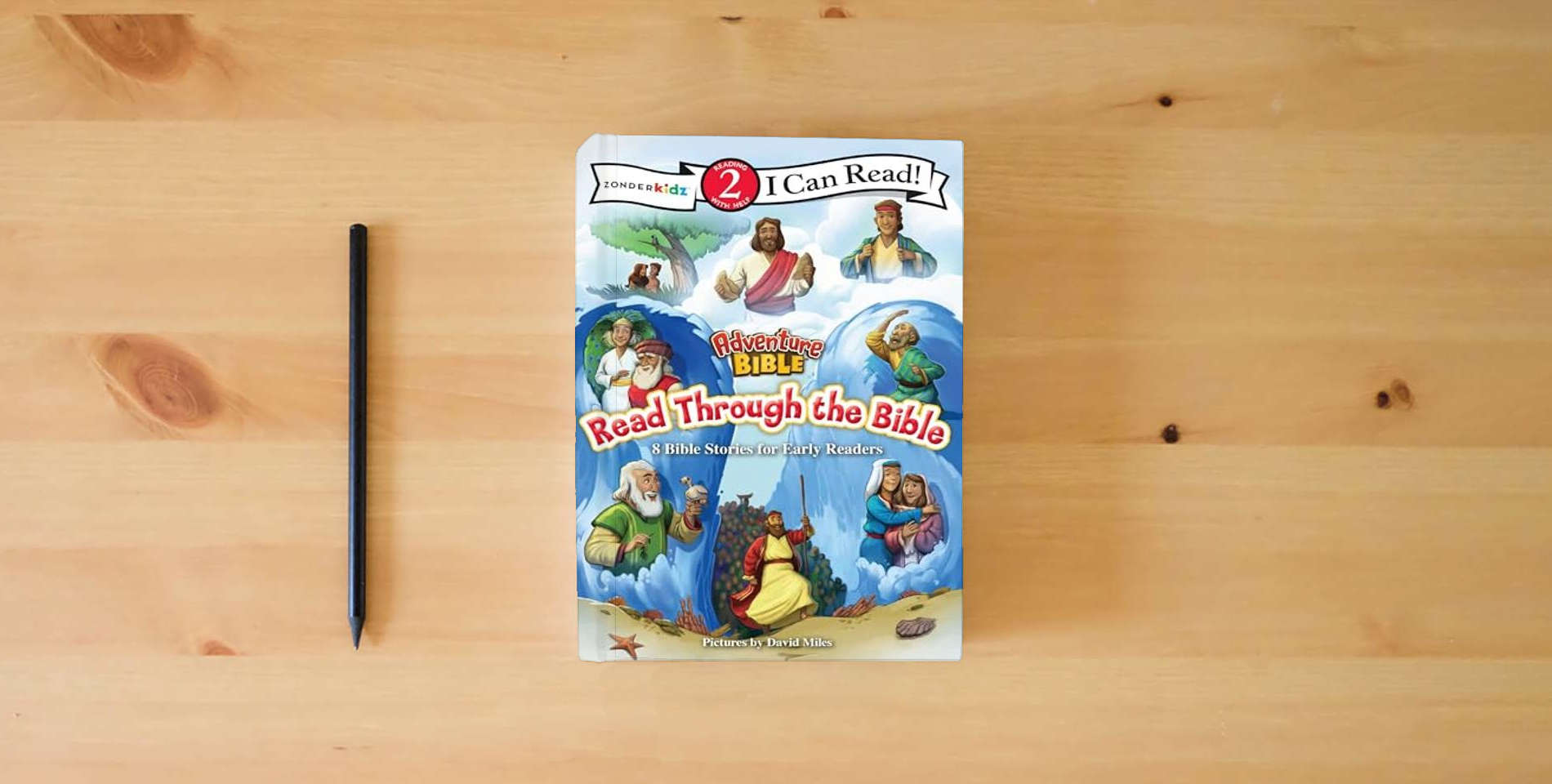 The book Adventure Bible Read Through the Bible: 8 Bible Stories for Early Readers (Level 2 I Can Read) is on the table
