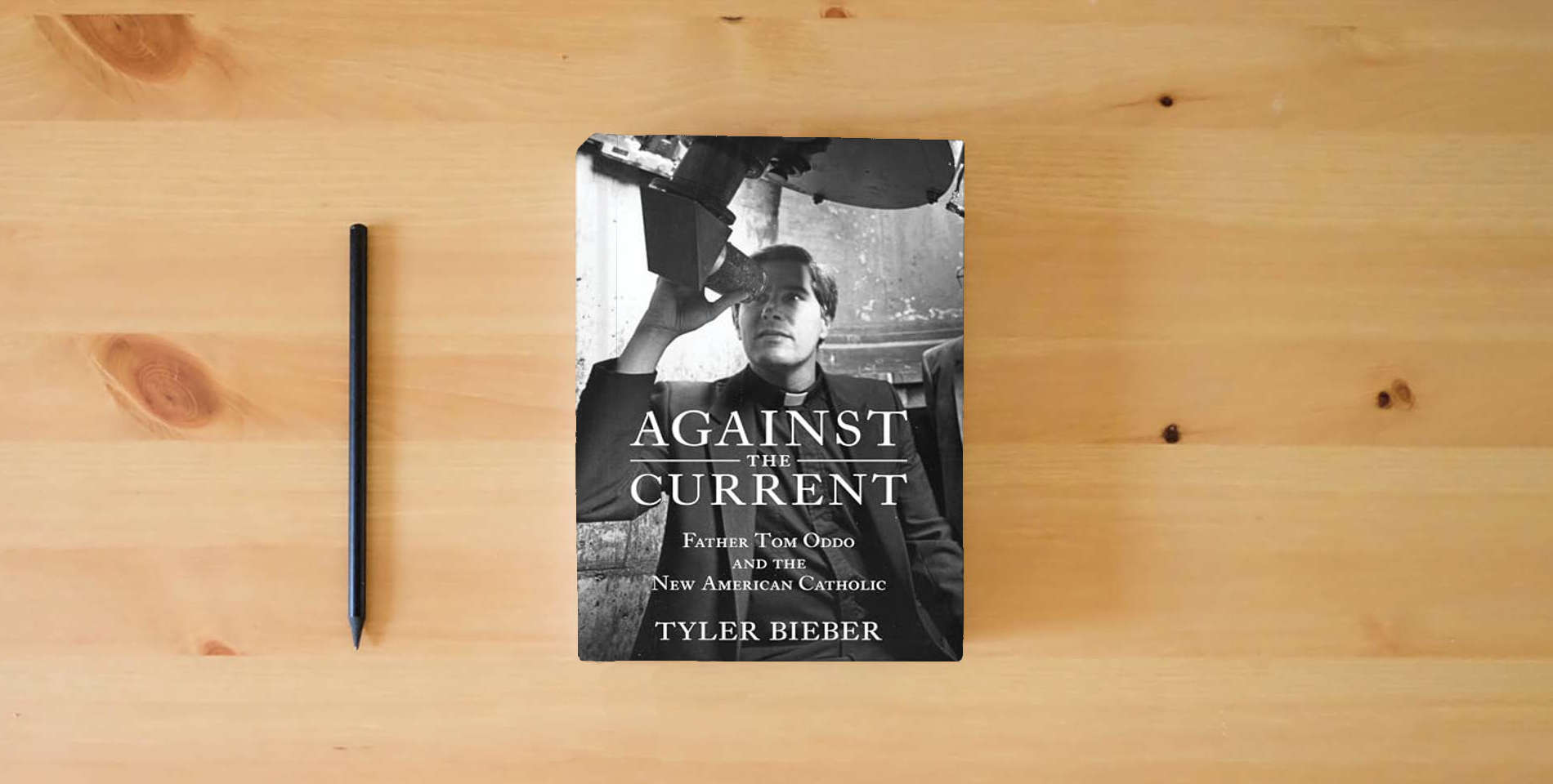The book Against the Current : Father Tom Oddo and the New American Catholic is on the table