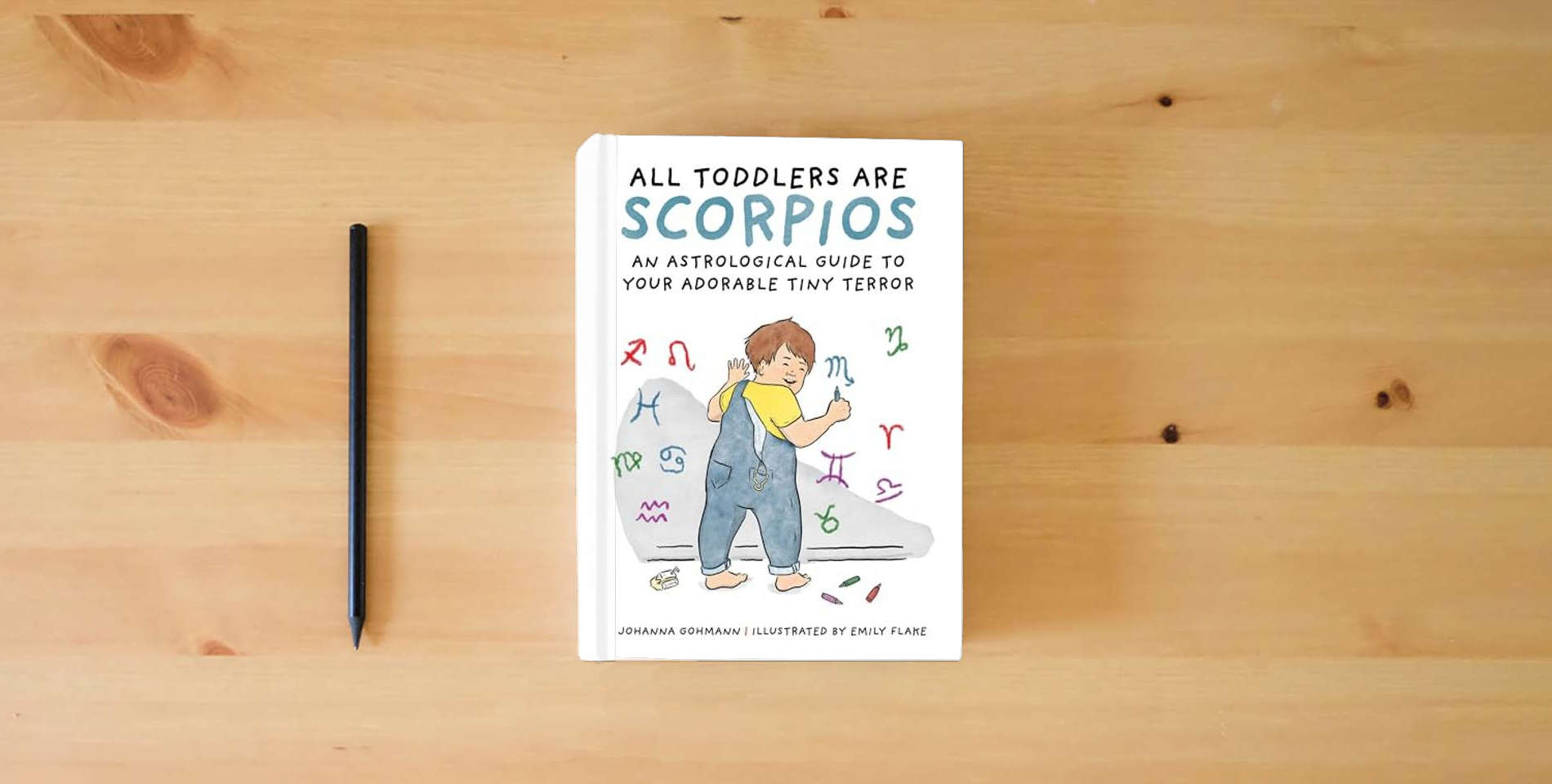The book All Toddlers Are Scorpios: An Astrological Guide to Your Adorable Tiny Terror is on the table