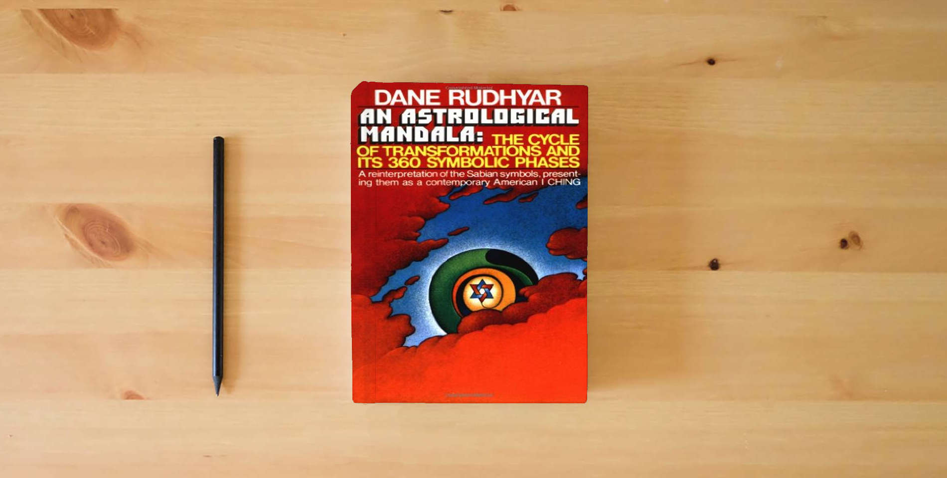 The book An Astrological Mandala: The Cycle of Transformations and Its 360 Symbolic Phases is on the table