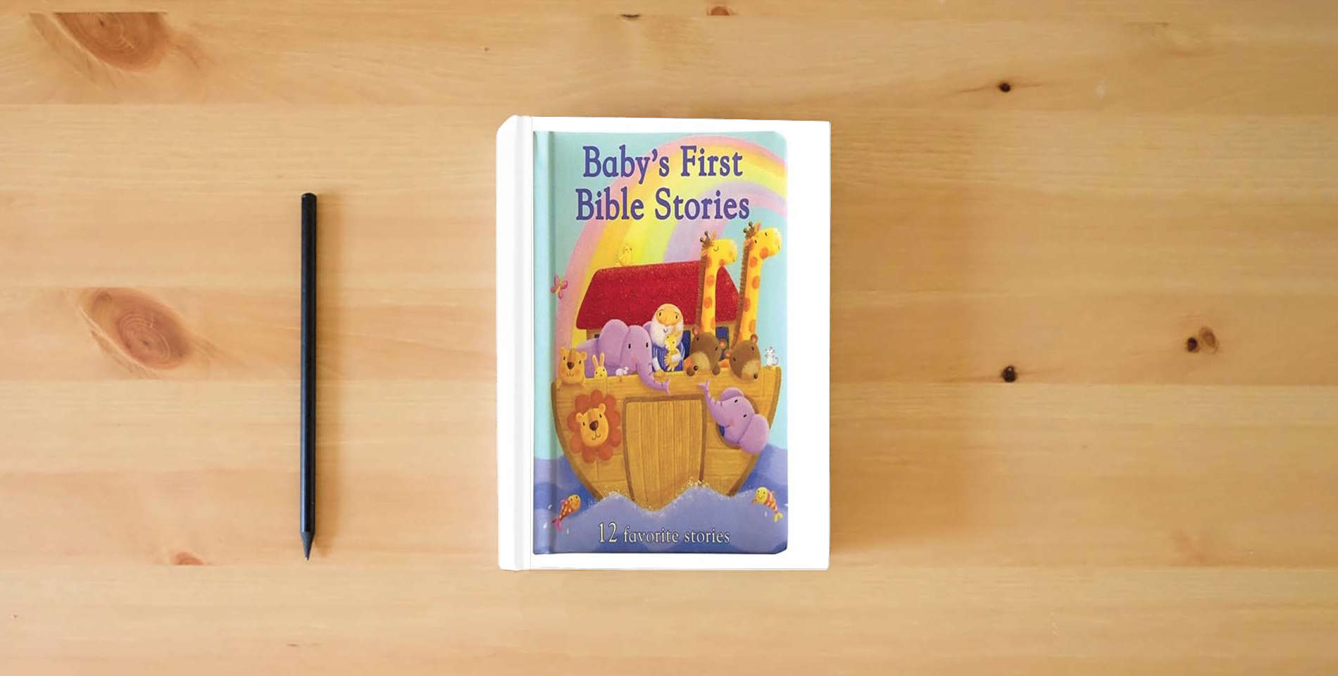 The book Baby's First Bible Stories Padded Board Book - Gift for Easter, Christmas, Communions, Newborns, Birthdays, Beginner Bible is on the table