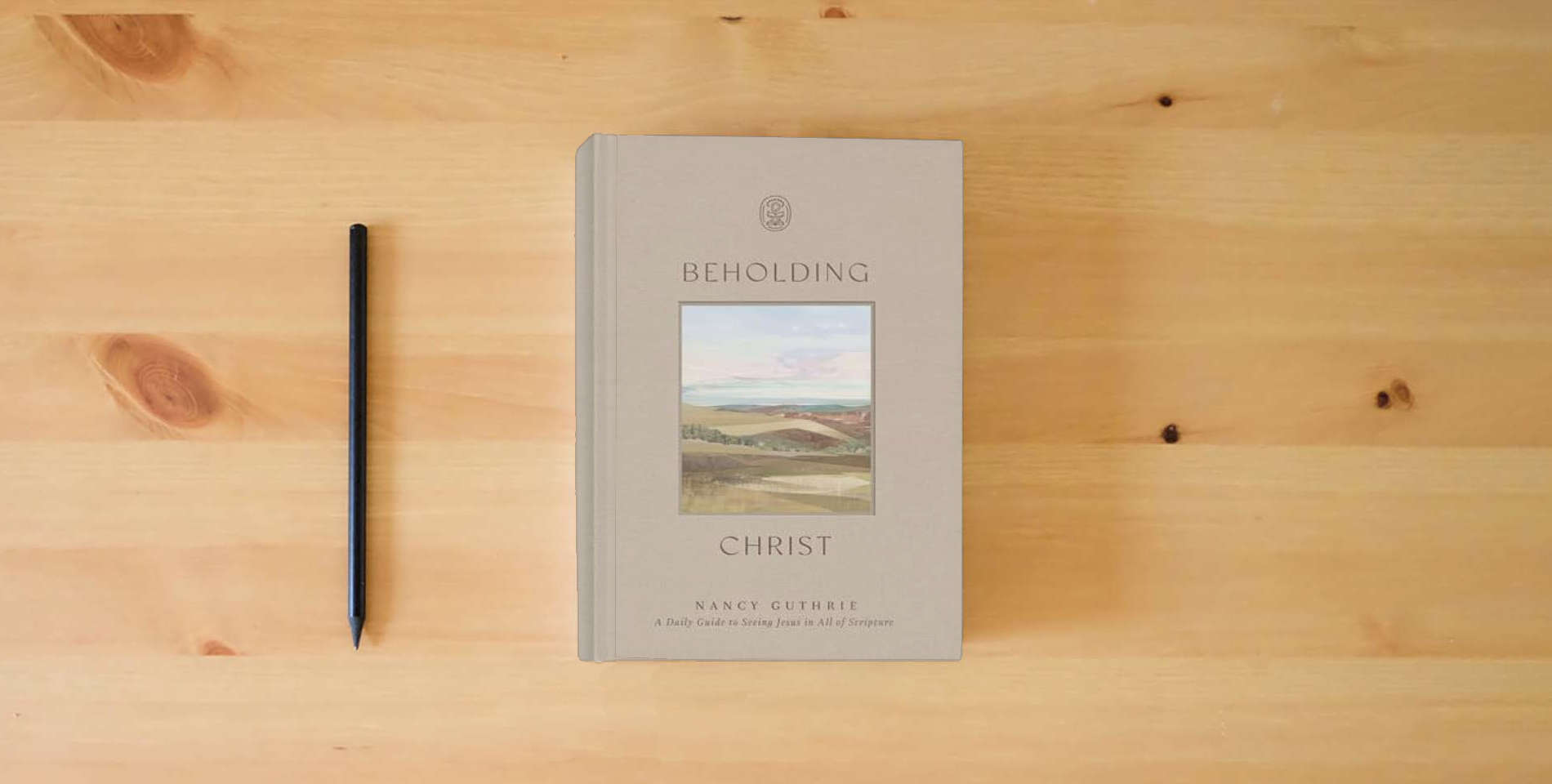 The book Beholding Christ: A Daily Guide to Seeing Jesus in All of Scripture is on the table
