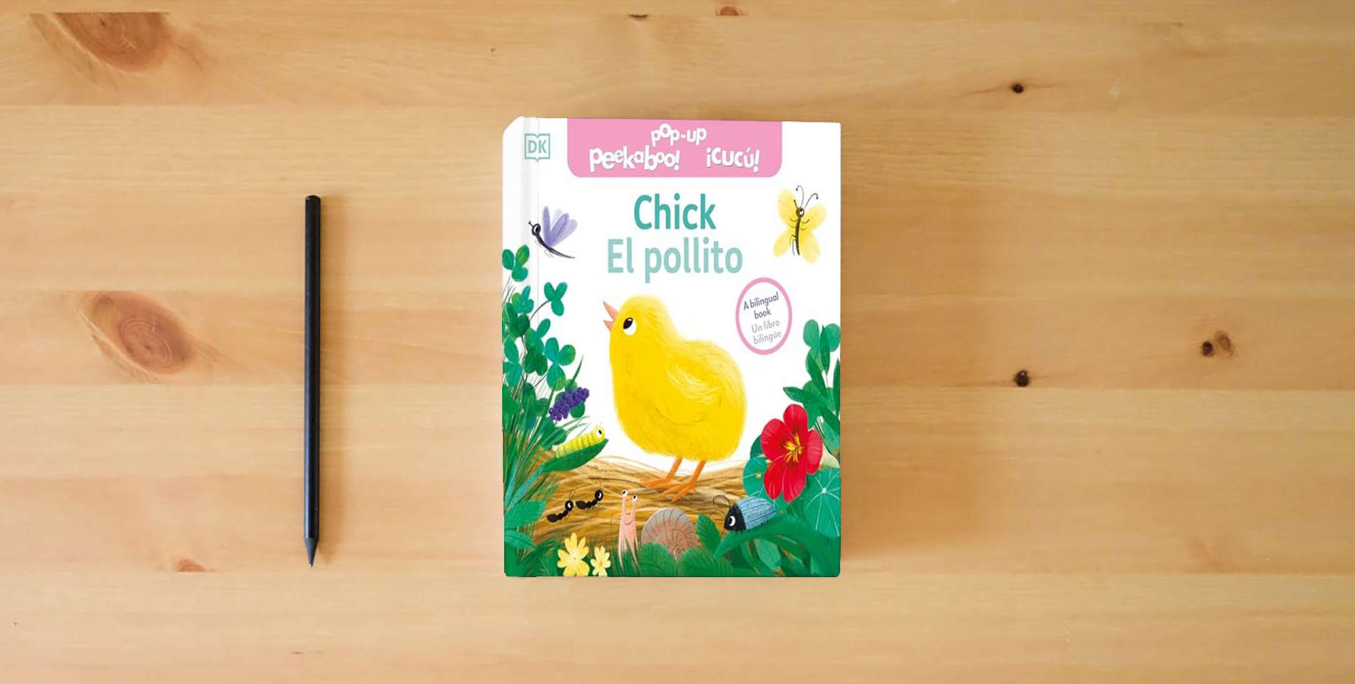 The book Bilingual Pop-Up Peekaboo! Chick / El pollito is on the table