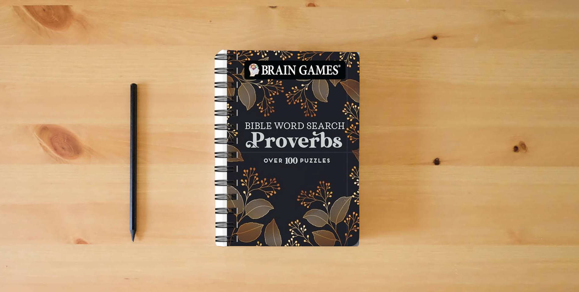 The book Brain Games - To Go - Bible Word Search: Proverbs is on the table