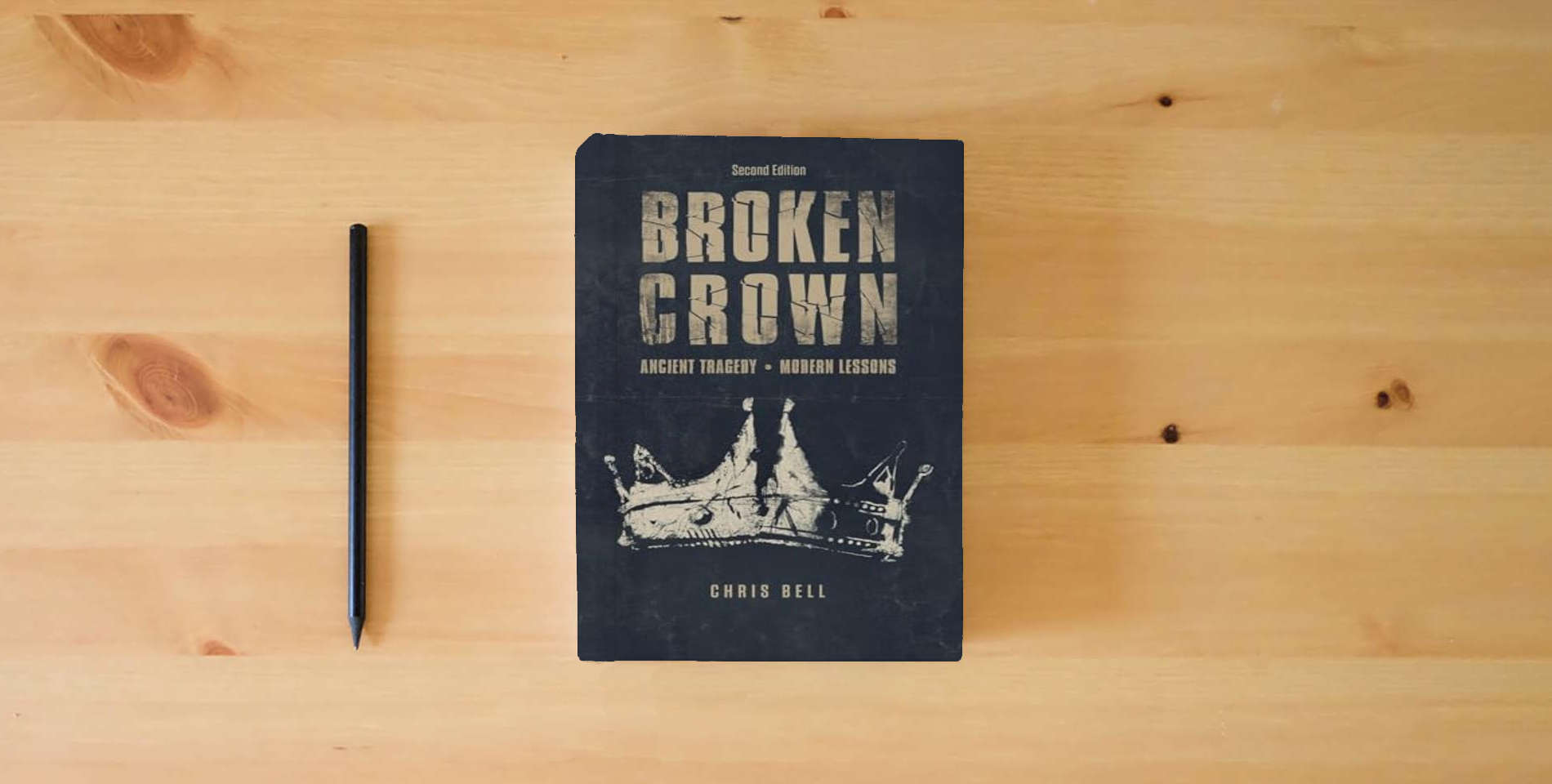 The book Broken Crown: Ancient Tragedy Modern Lessons: Second Edition is on the table