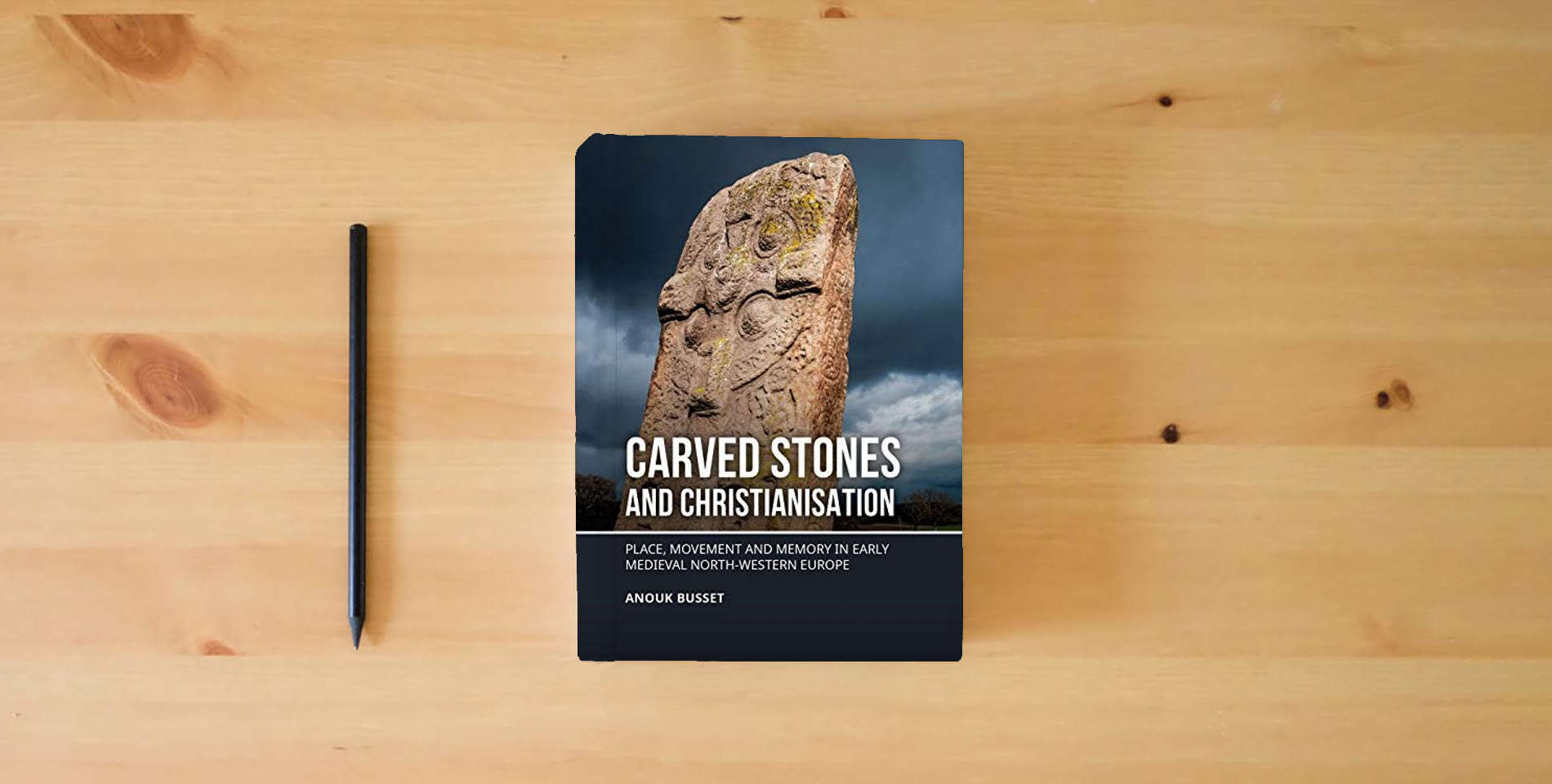 The book Carved stones and Christianisation: Place, movement and memory in early medieval north-western Europe is on the table