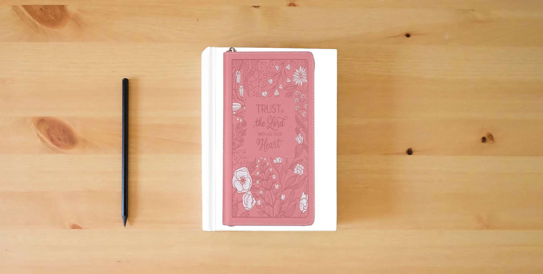 The book Christian Art Gifts Pink Vegan Leather Zipped Journal, Inspirational Notebook Trust in the Lord Scripture, Flexible Cover, 336 Ruled Pages, Bookmark, Proverbs 3:5 Bible Verse is on the table
