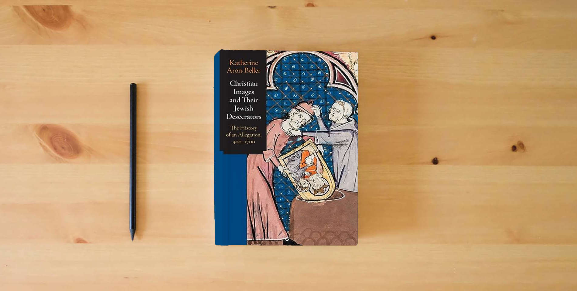The book Christian Images and Their Jewish Desecrators: The History of an Allegation, 400-1700 (Jewish Culture and Contexts) is on the table