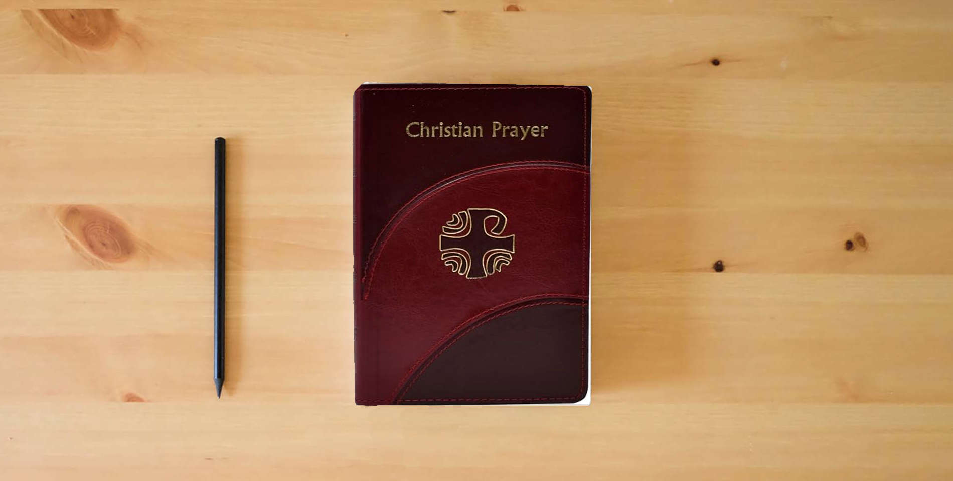 The book Christian Prayer [Imitation Leather] International Commission on English in the Liturgy is on the table