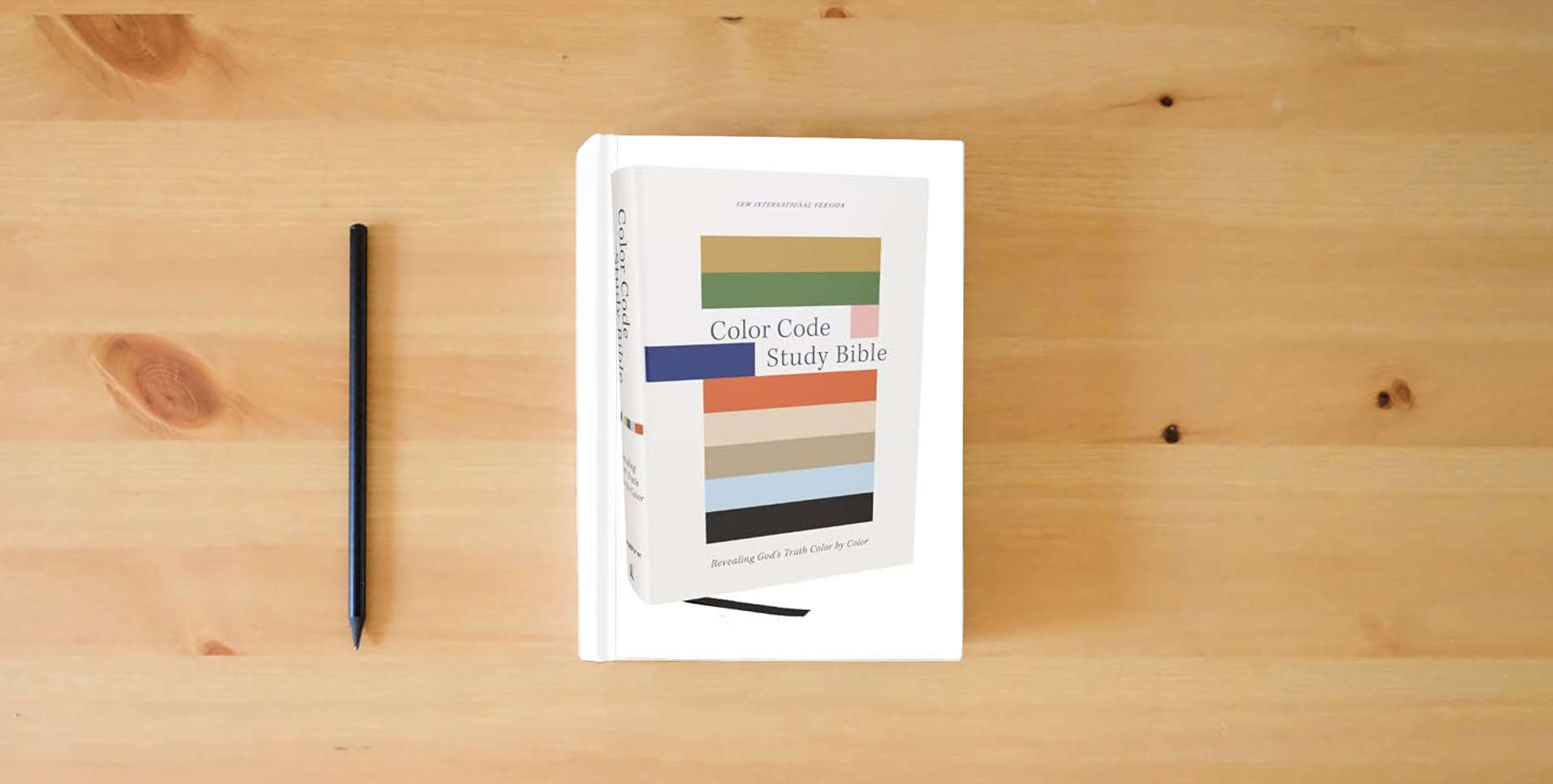 The book Color Code Study Bible, Revealing God's Truth Color by Color (NIV, Hardcover, Red Letter, Comfort Print) is on the table