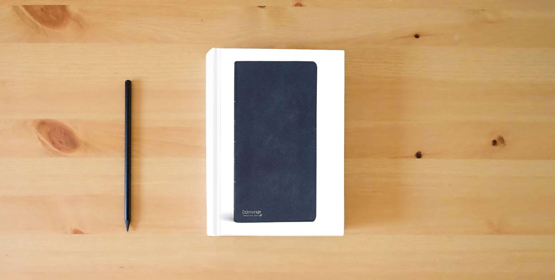 The book CSB (in)courage Devotional Bible, Navy Genuine Leather, Black Letter, Full-Color Design, Devotionals, Journaling Space, Reading Plans, Easy-to-Read Bible Serif Type is on the table