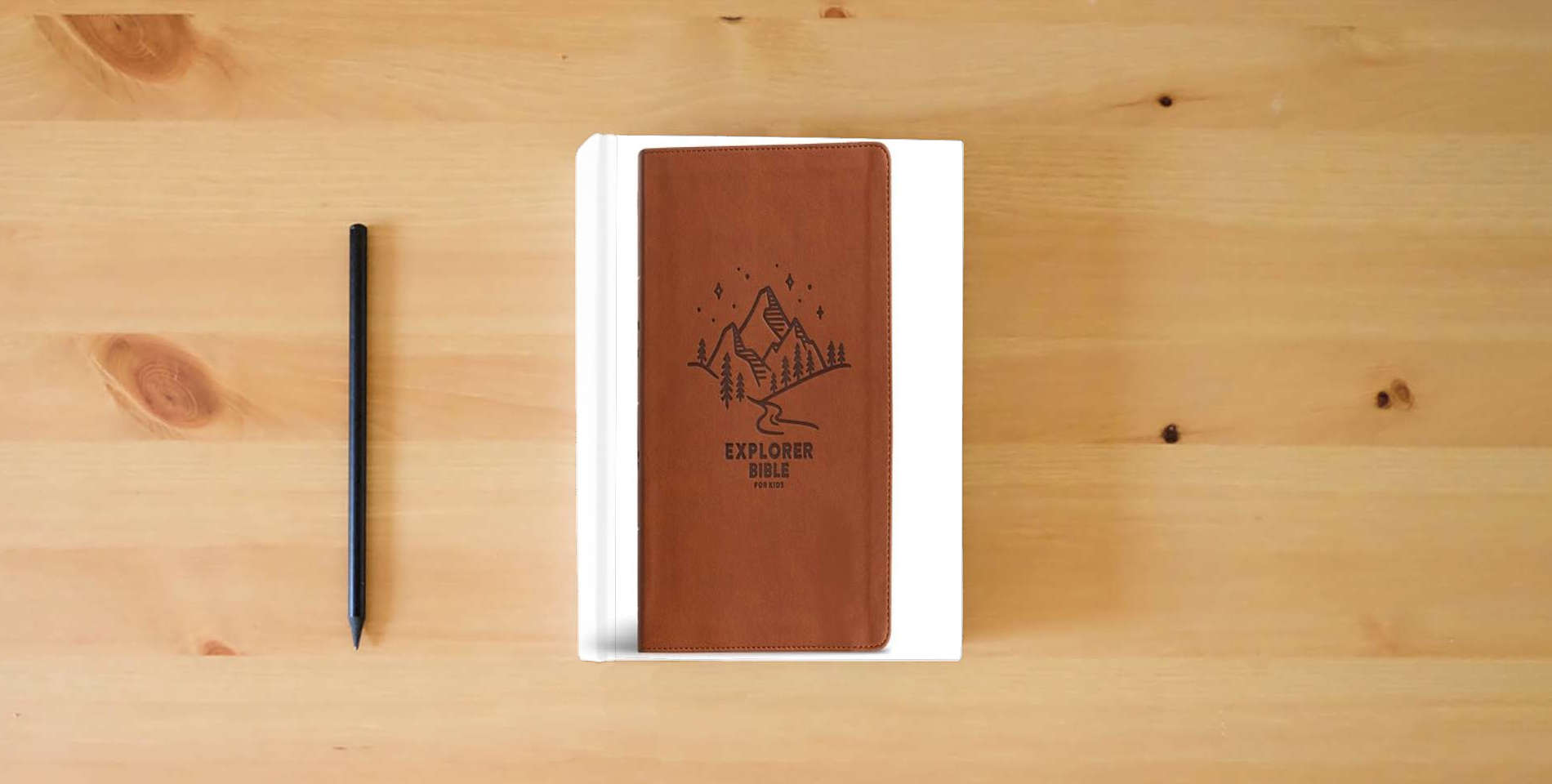 The book CSB Explorer Bible for Kids, Brown Mountains LeatherTouch, Red Letter, Full-Color Design, Photos, Illustrations, Charts, Videos, Activities, Easy-to-Read Bible Serif Type is on the table