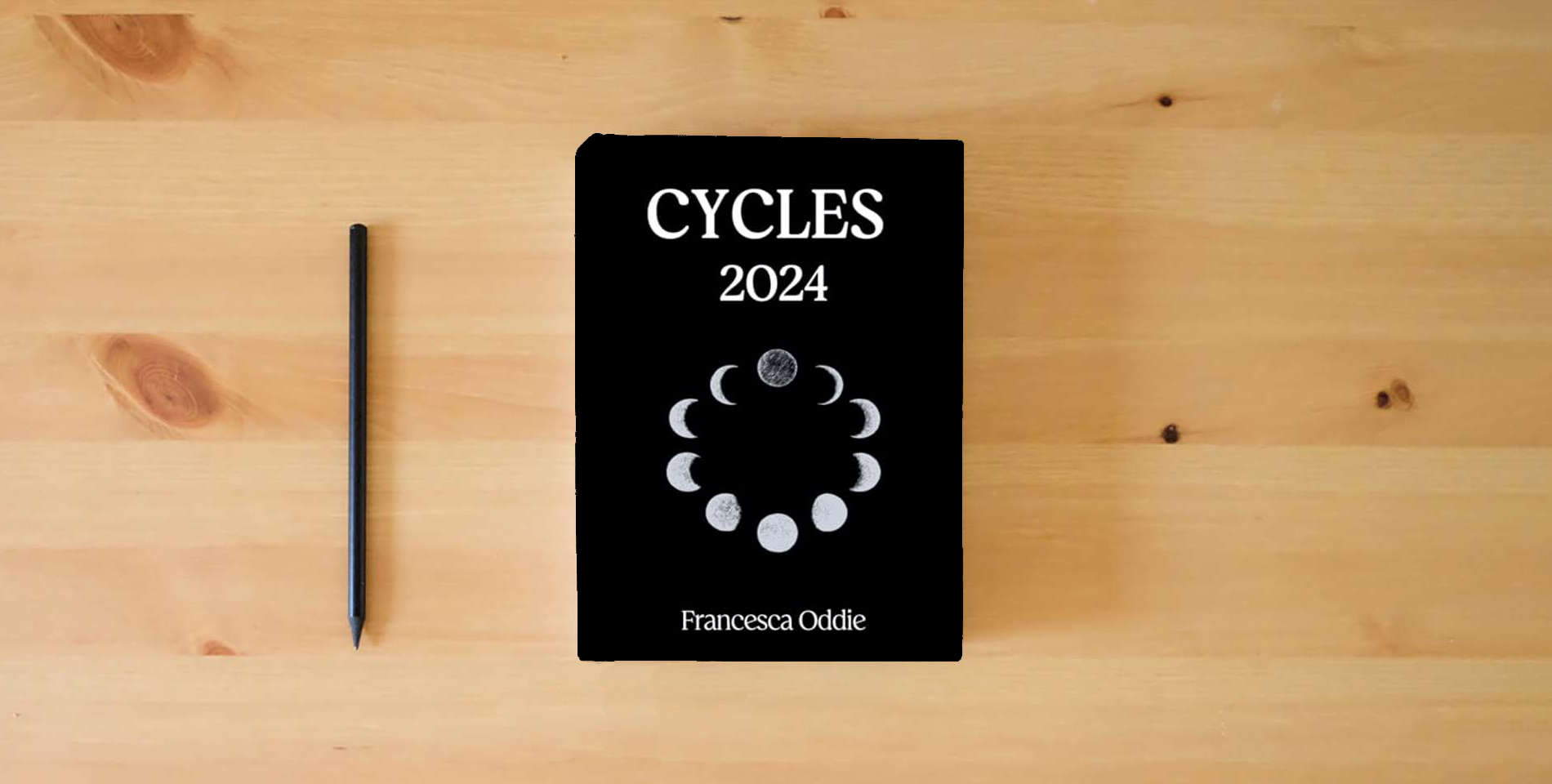 The book CYCLES 2024: A Magical Moon Journal is on the table