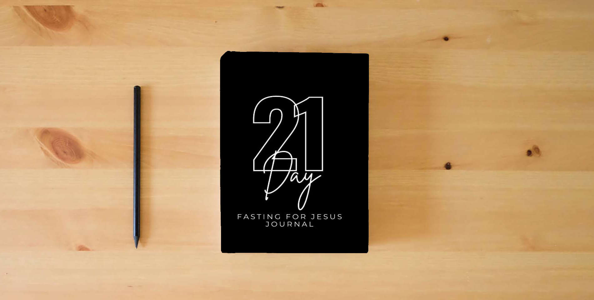 The book 21 DAY BIBLICAL FASTING AND PRAYER JOURNAL is on the table
