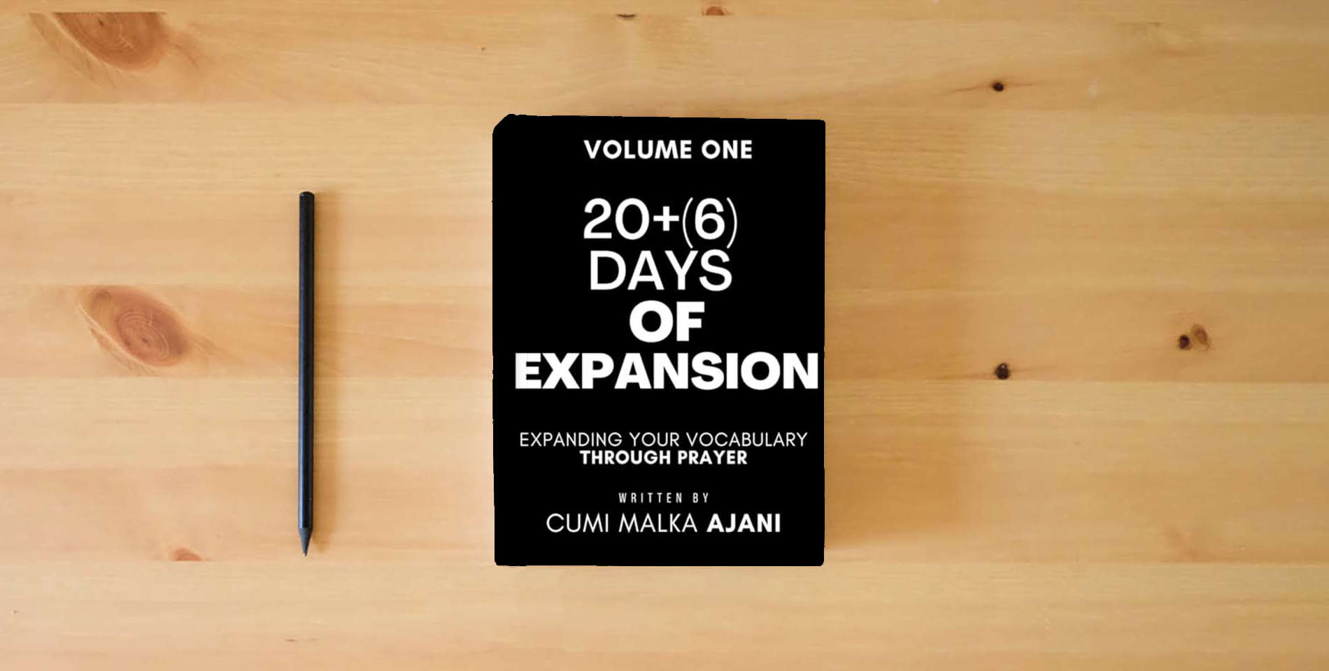 The book 26 Days of Expansion: Expanding your Vocabulary through Prayer is on the table