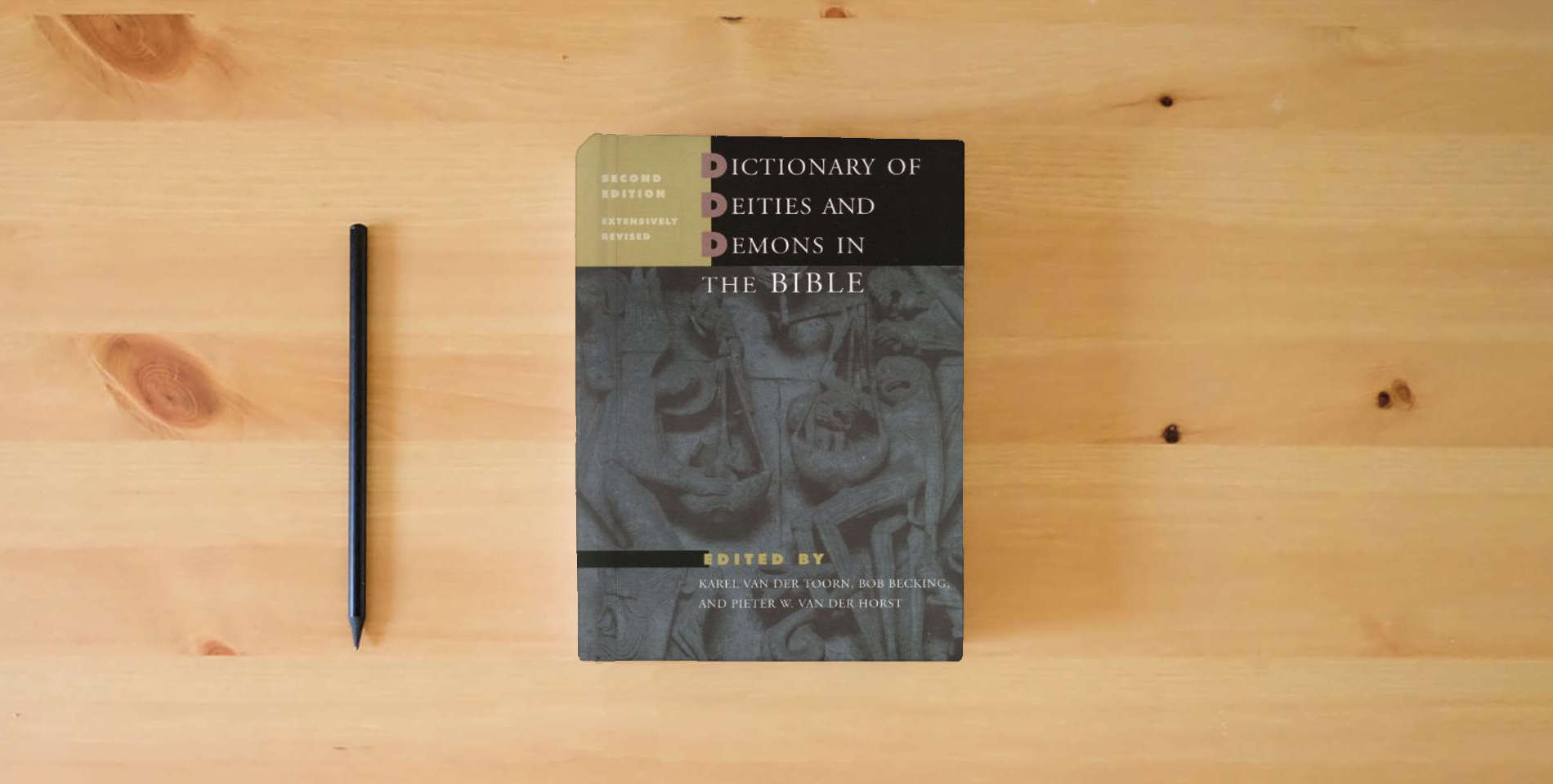 The book Dictionary of Deities and Demons in the Bible: Second Extensively Revised Edition is on the table