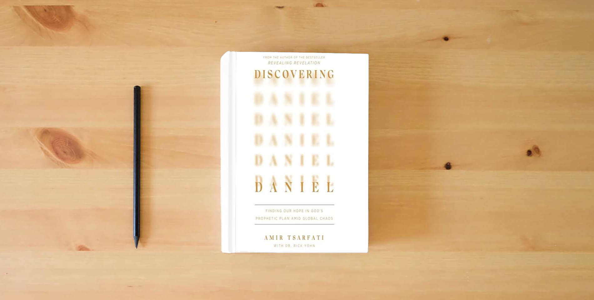 The book Discovering Daniel: Finding Our Hope in God's Prophetic Plan Amid Global Chaos is on the table
