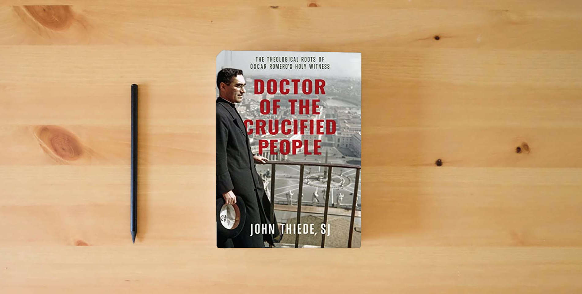The book Doctor of the Crucified People: The Theological Roots of Óscar Romero's Holy Witness is on the table