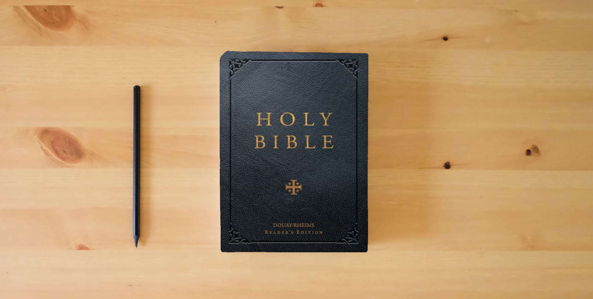 The book Douay-Rheims Reader's Bible (Black Leatherette) is on the table