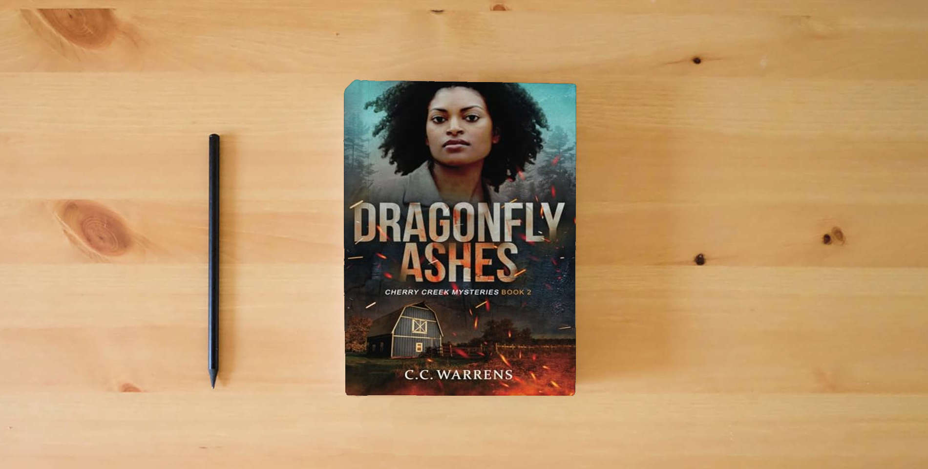 The book Dragonfly Ashes (Cherry Creek Mysteries) is on the table