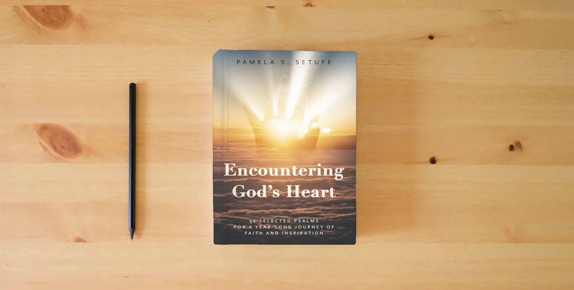 The book Encountering God's Heart: 52 Selected Psalms for a Year-Long Journey of Faith and Inspiration is on the table