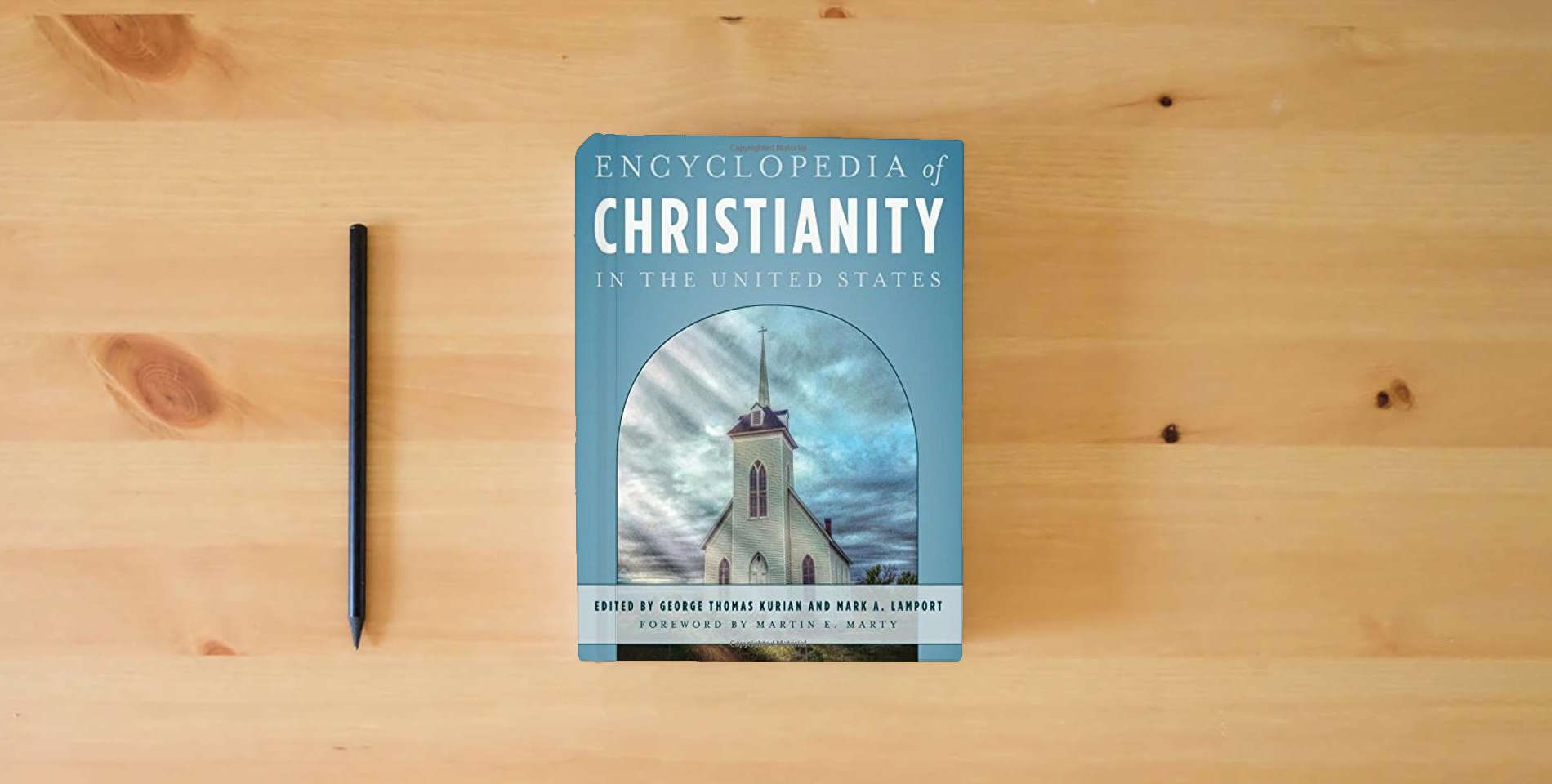 The book Encyclopedia of Christianity in the United States (5 Volume Set) is on the table