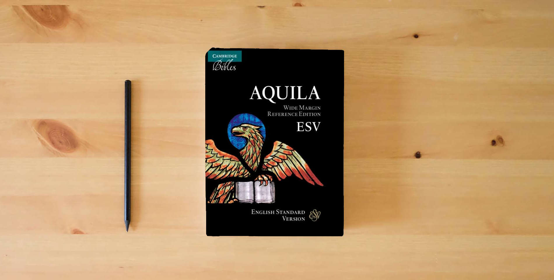 The book ESV Aquila Wide Margin Reference Bible, Black Goatskin Leather Edge-lined, Red-letter Text, ES746:XRME is on the table