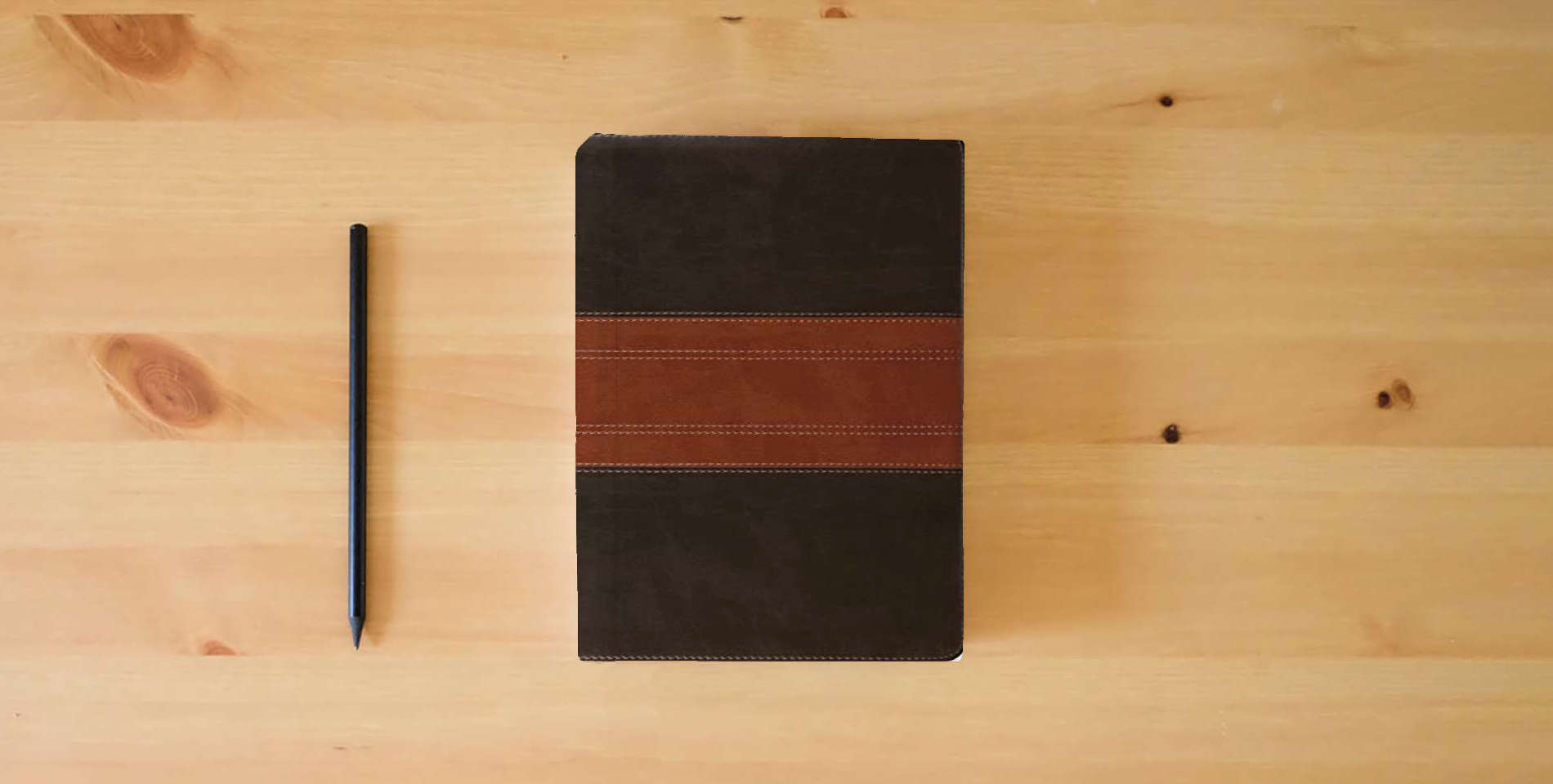 The book ESV Large Print Personal Size Bible, Red Letter, Thumb Indexed (TruTone, Forest/Tan, Trail Design): Holy Bible, English Standard Version is on the table