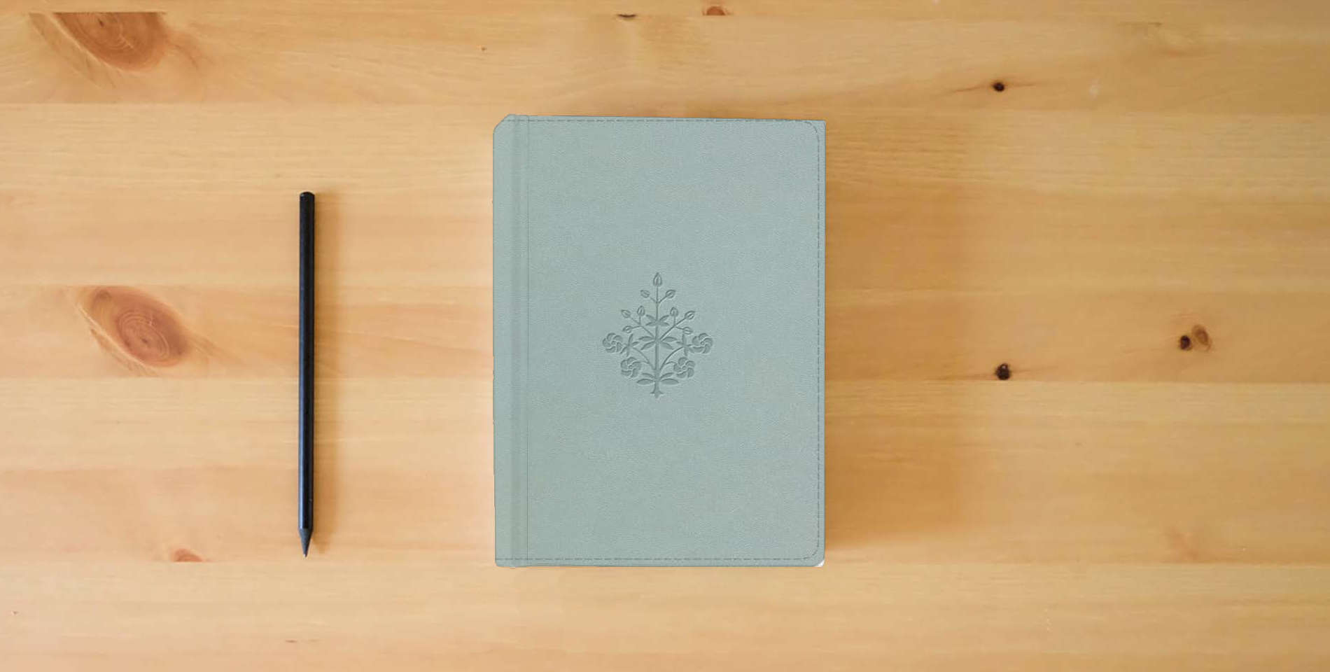 The book ESV Large Print Value Personal Size Bible, Red Letter (TruTone, River Stone, Branch Design) is on the table
