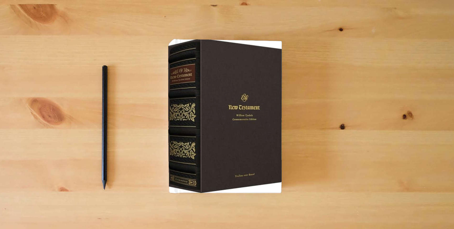 The book ESV New Testament with Illuminated Drop Caps: William Tyndale Commemorative Edition (TruTone over Board) is on the table