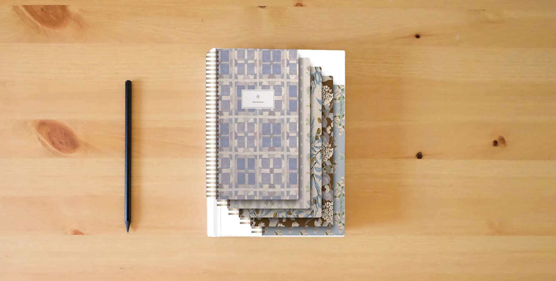 The book ESV Spiral-Bound Journaling Bible, Five-Volume Set (Hardcover, Cover Artwork by Lulie Wallace) is on the table
