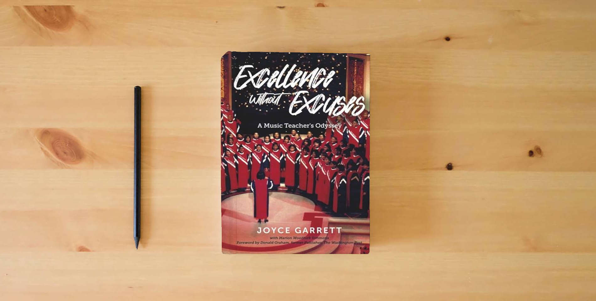 The book Excellence Without Excuses...A Music Teacher's Odyssey is on the table