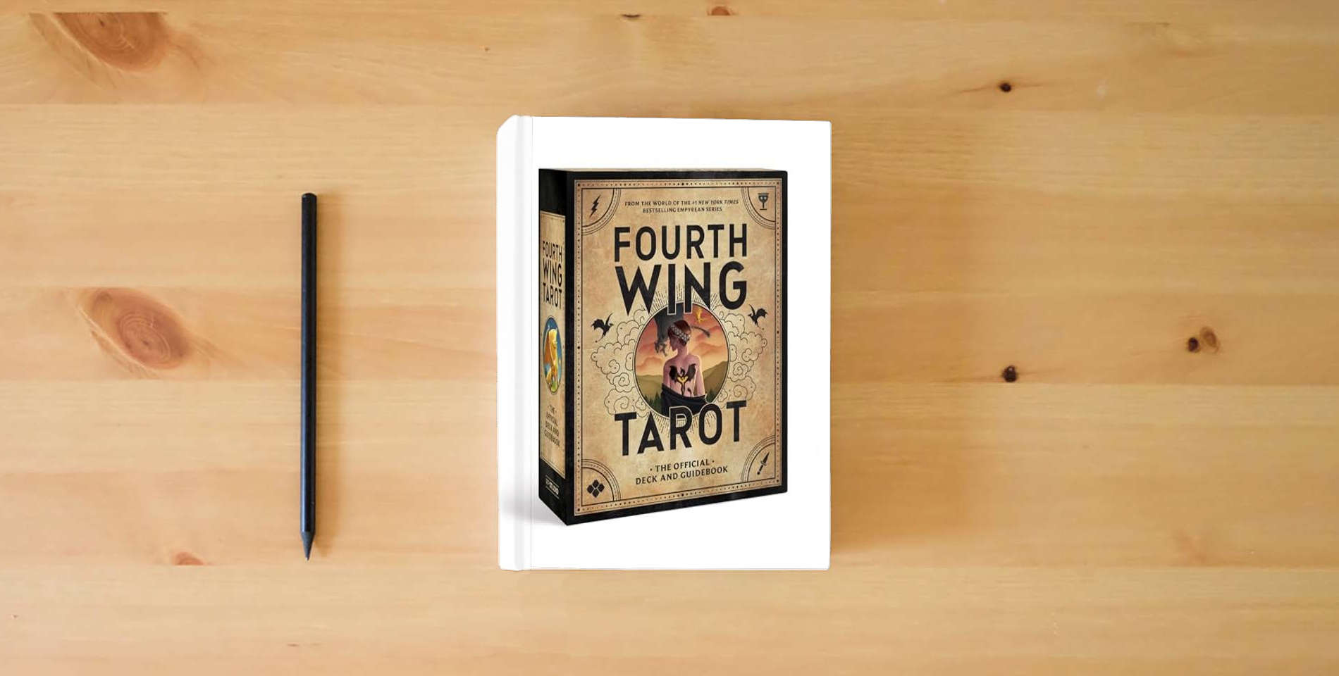 The book Fourth Wing Tarot: The Official Deck and Guidebook from the World of the Empyrean Series is on the table