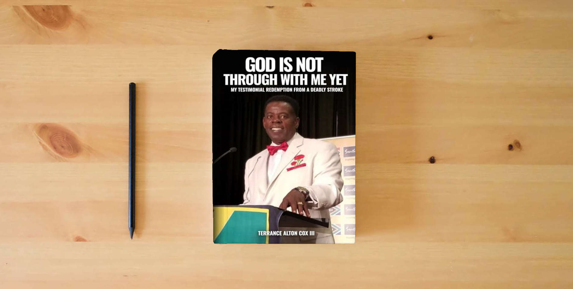 The book God Is Not Through With Me Yet: My Testimonial: Redemption From A Deadly Stroke is on the table