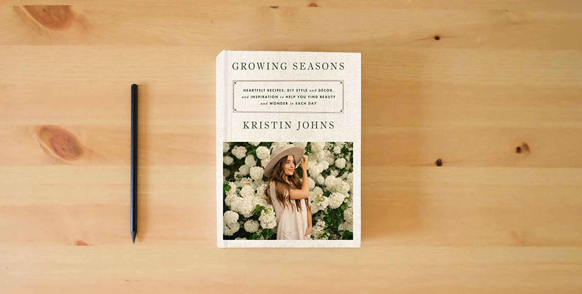 The book Growing Seasons: Heartfelt Recipes, DIY Style and Décor, and Inspiration to Help You Find Beauty and Wonder in Each Day is on the table
