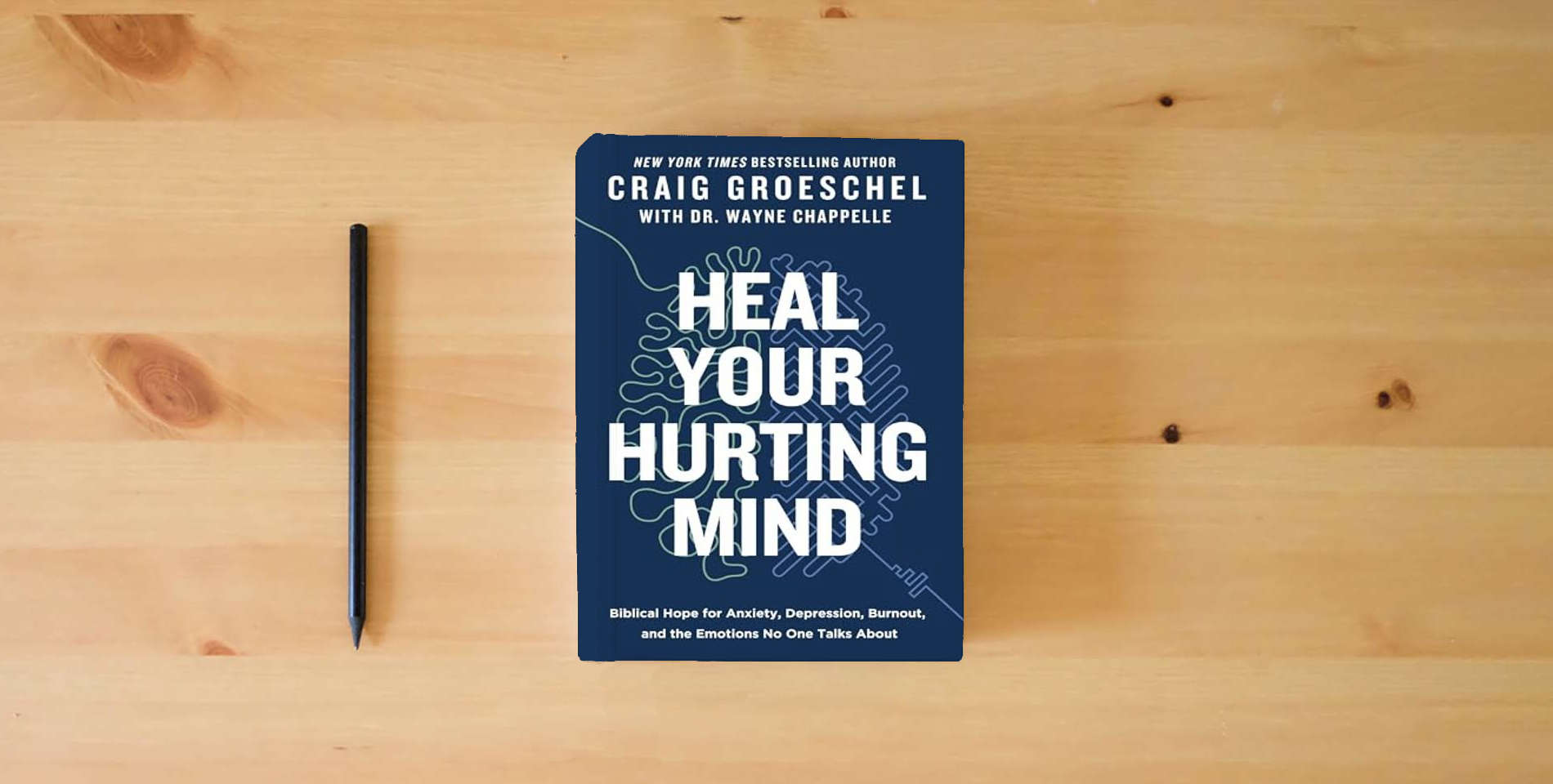 The book Heal Your Hurting Mind: Biblical Hope for Anxiety, Depression, Burnout, and the Emotions No One Talks About is on the table