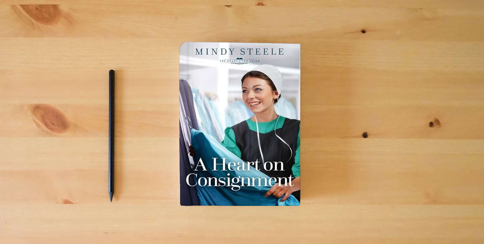 The book A Heart on Consignment (The Heart of the Amish) is on the table