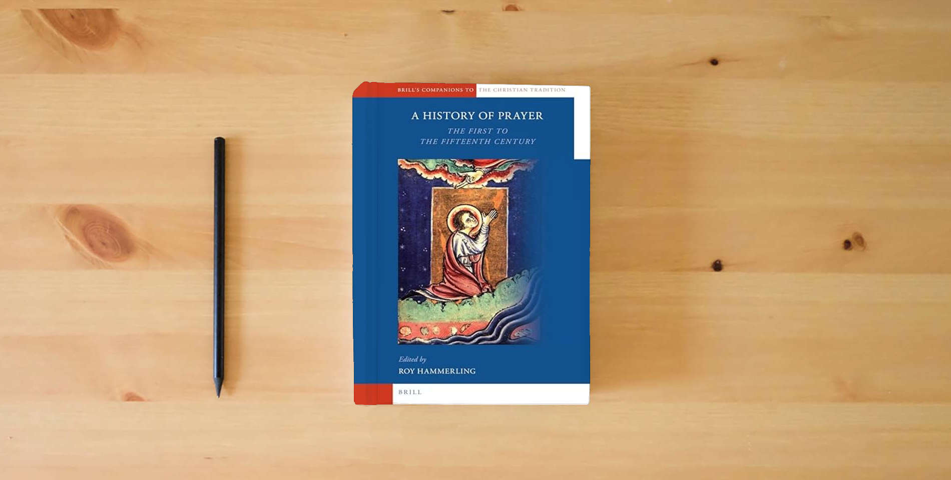 The book A History of Prayer: The First to the Fifteenth Century (Brill's Companions to the Christian Tradition, 13) is on the table