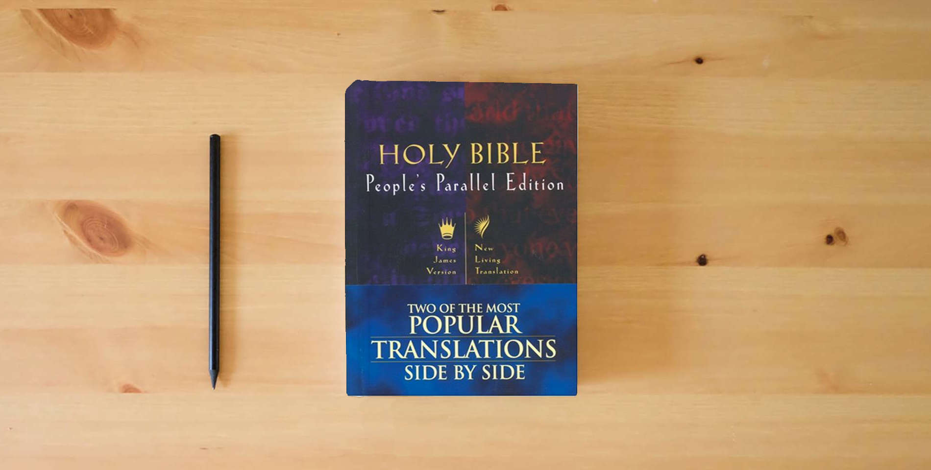The book Holy Bible: People's Parallel Edition (King James Version/New Living Translation) is on the table