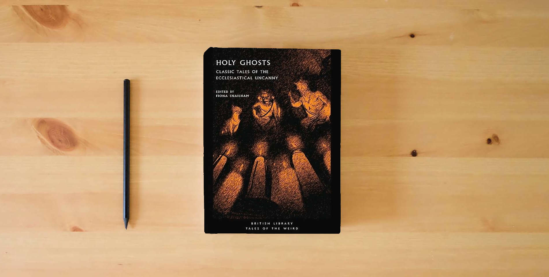 The book Holy Ghosts: Classic Tales of the Ecclesiastical Uncanny (Tales of the Weird) is on the table