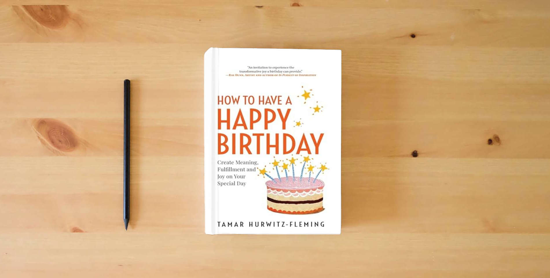 The book How to Have a Happy Birthday: Create Meaning, Fulfillment and Joy on Your Special Day is on the table