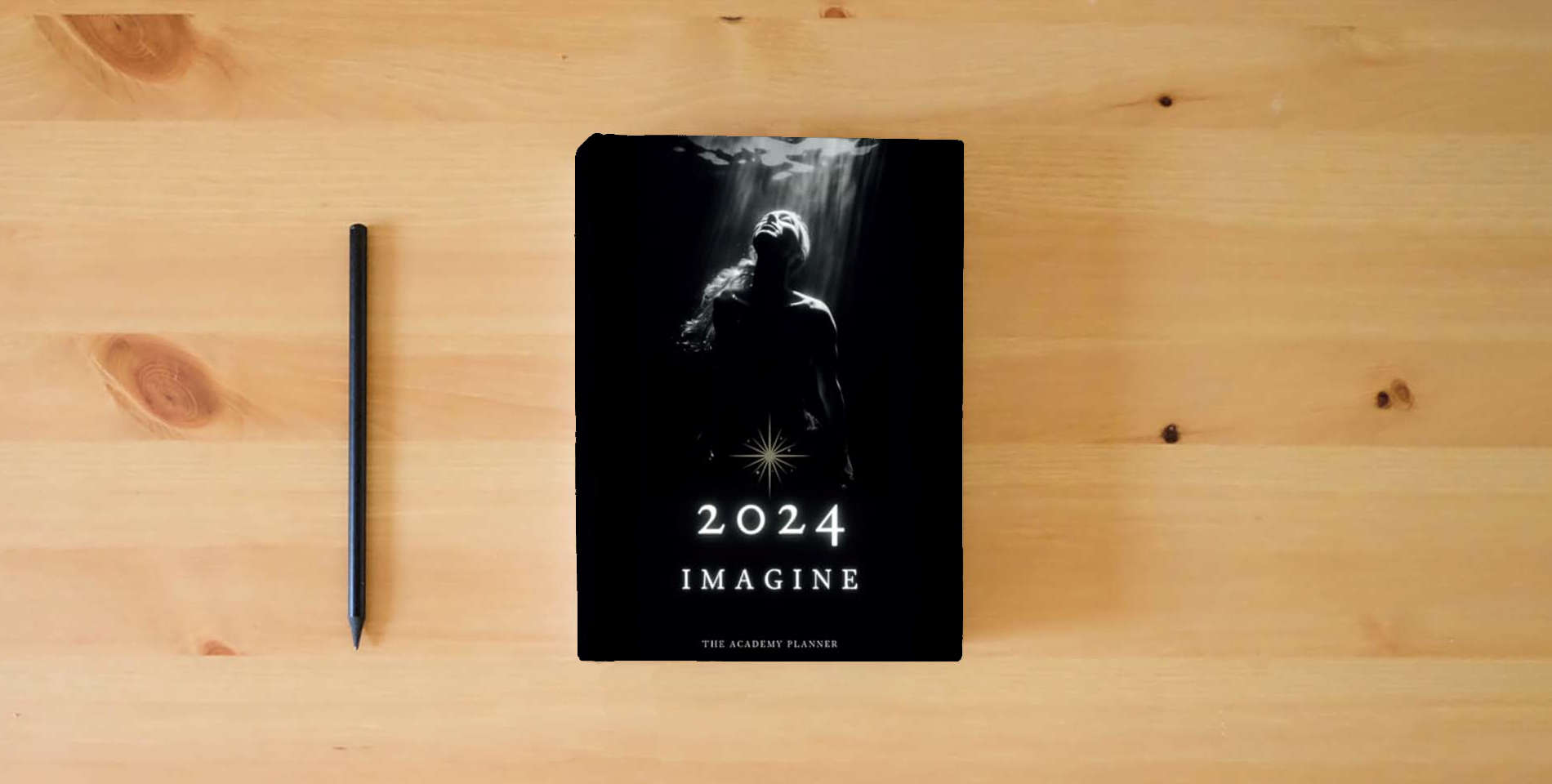 The book Imagine 2024: The Academy Planner is on the table