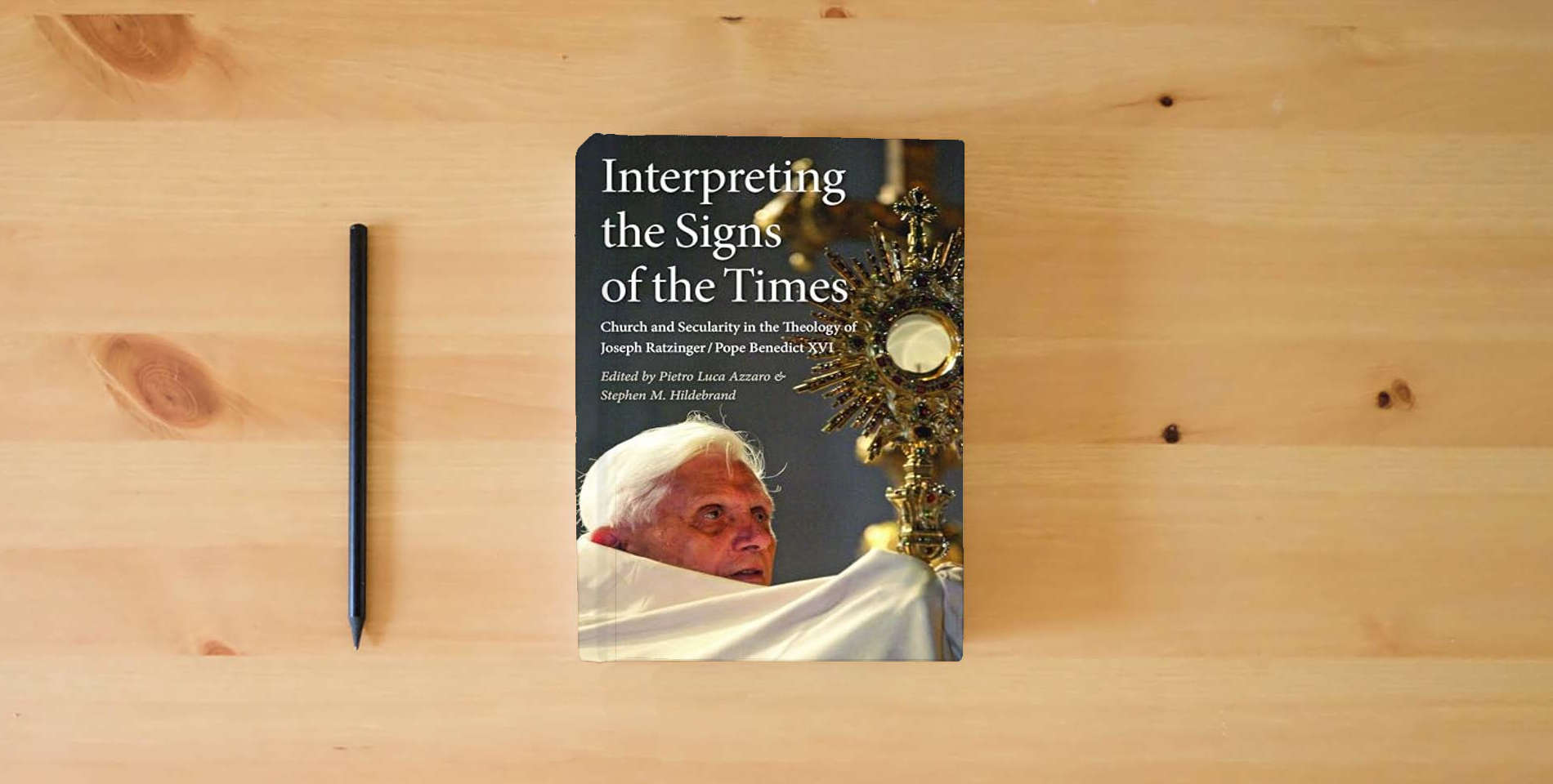 The book Interpreting the Signs of the Times: Church and Secularity in the Theology of Joseph Ratzinger/Pope Benedict XVI is on the table
