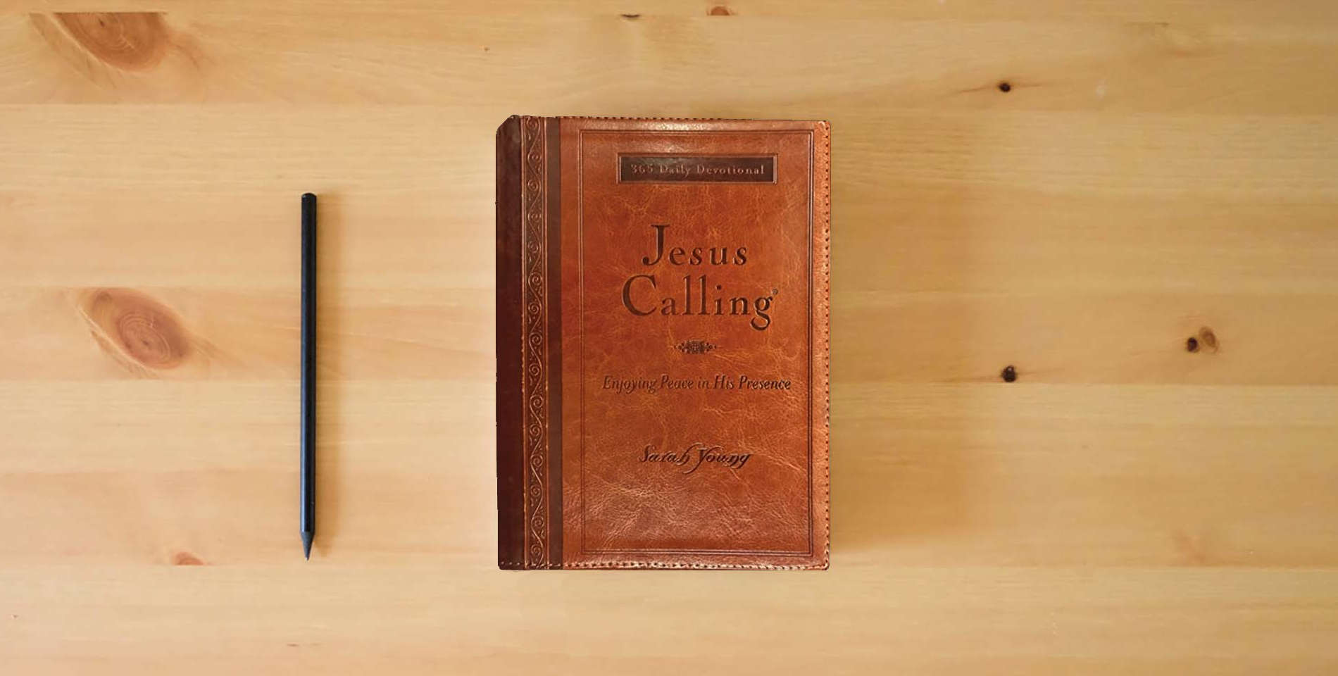 The book Jesus Calling, Large Text Brown Leathersoft, with Full Scriptures: Enjoying Peace in His Presence (A 365-Day Devotional) is on the table