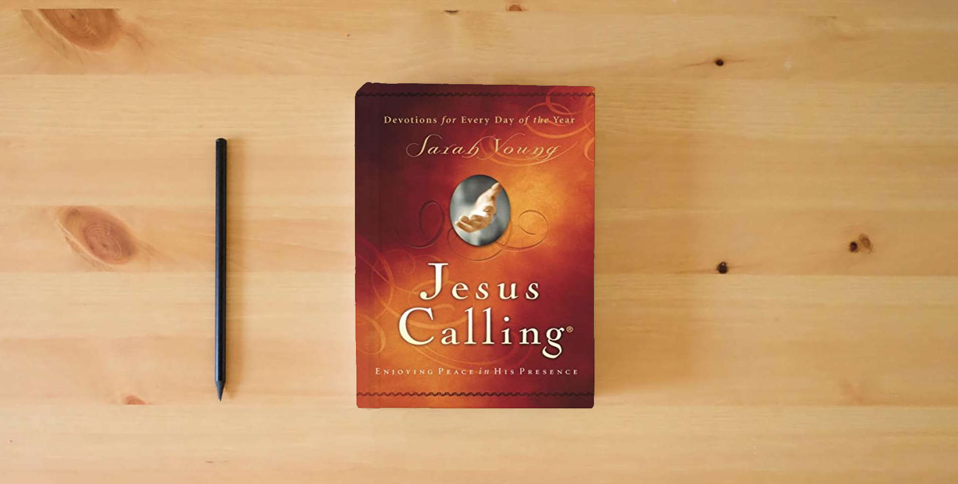 The book Jesus Calling, Padded Hardcover, with Scripture references: Enjoying Peace in His Presence (A 365-Day Devotional) is on the table