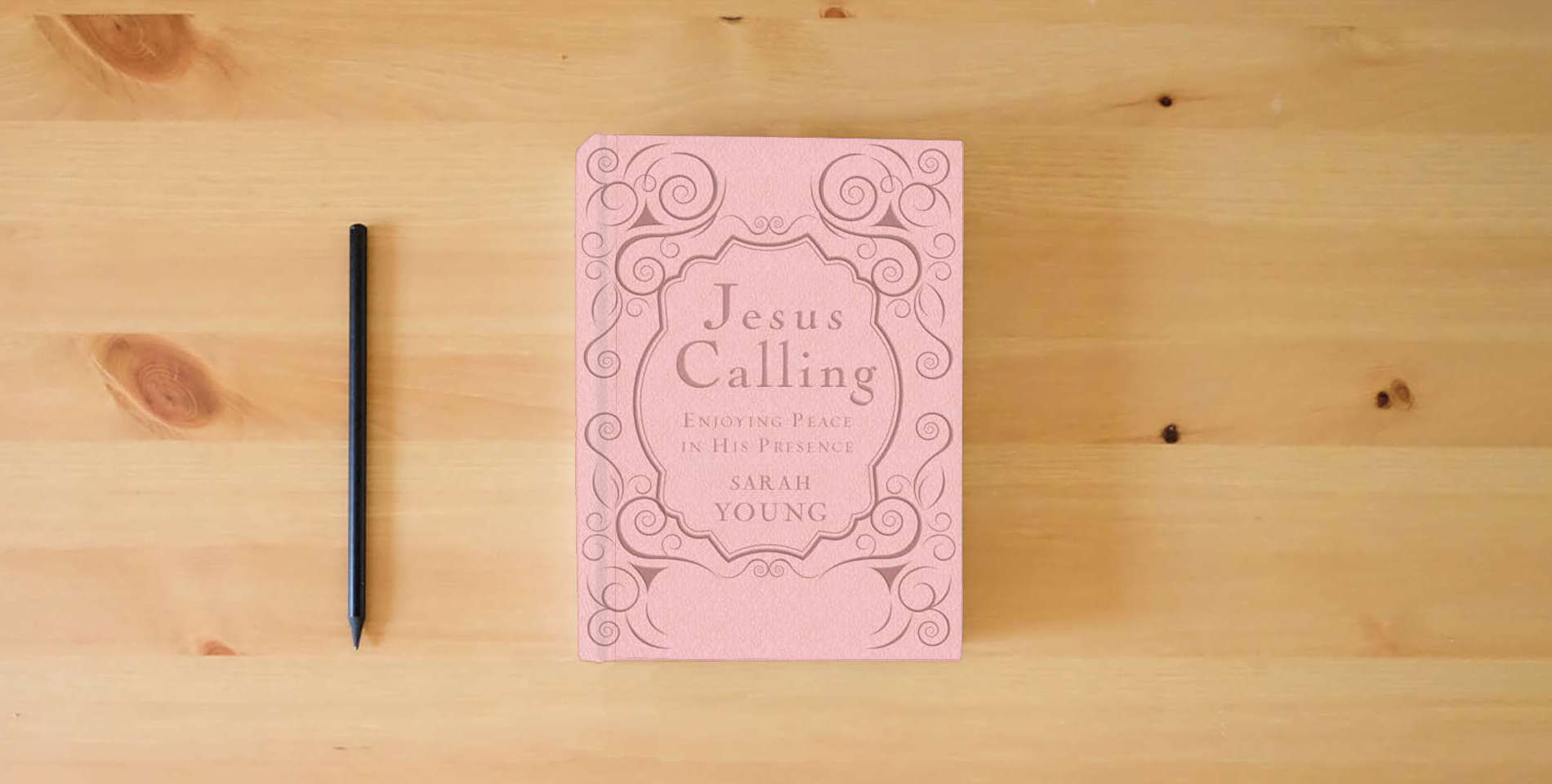 The book Jesus Calling, Pink Leathersoft, with Scripture References: Enjoying Peace in His Presence (A 365-Day Devotional) is on the table